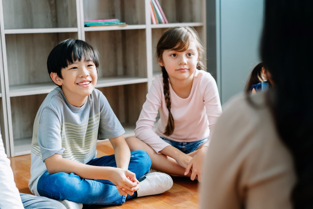 how to help a child with anger issues, two children in conversation with their therapist