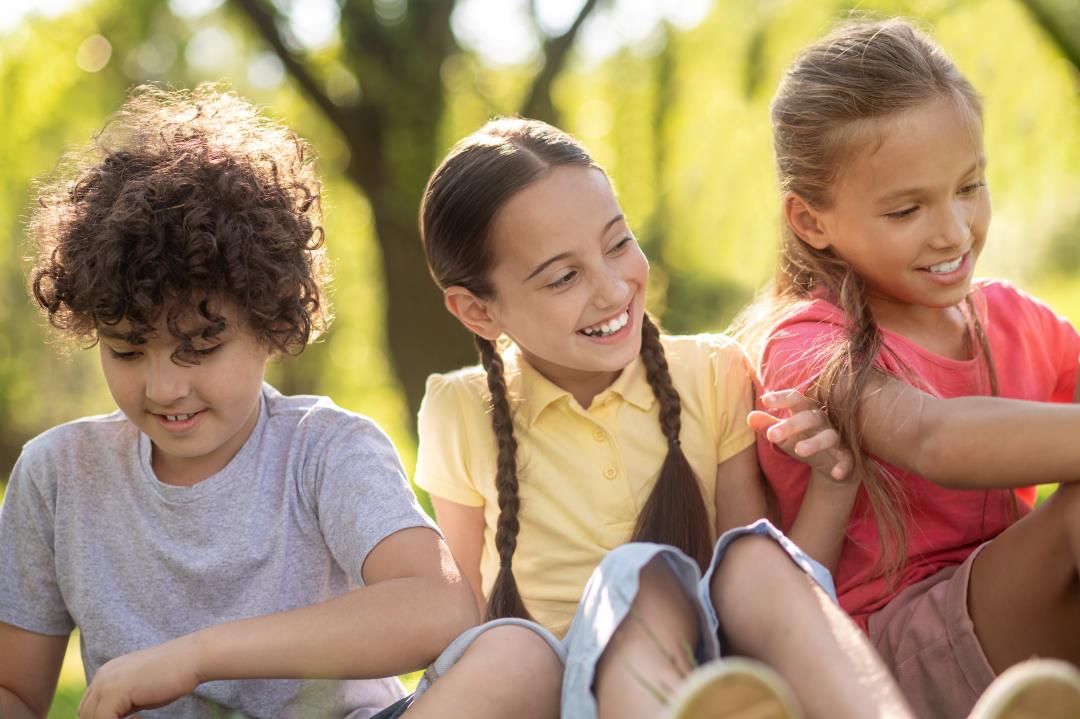 how to help a child with anger issues, children sitting together outdoors